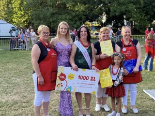 Pięć kobiet w odświętnych strojach ludowych i balowych oraz jedna mala dziewczynka. Sceneria festiwalowa 