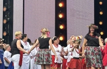 Kilkanaście kobiet w ludowych strojach na scenie festiwalu 